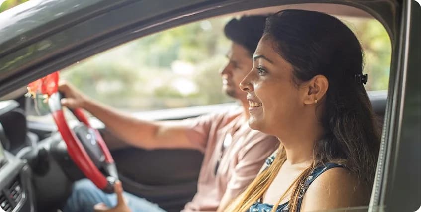 Couple enjoying a self-drive car ride on a bright day