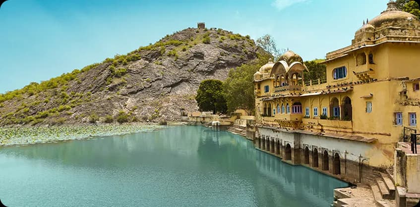 Traditional Rajasthani palace architecture beside a turquoise water tank in Bundi