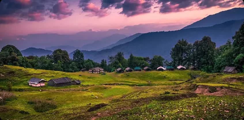 Chopta meadows and mountain huts under a pink purple sunset sky