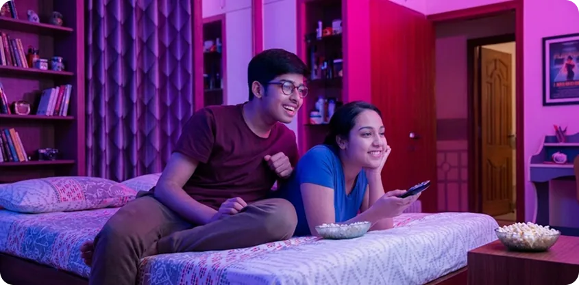 Siblings watching a movie at home with popcorn